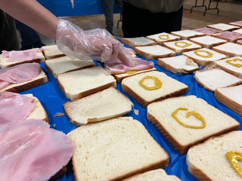 Pieces of bread on a table with mustard on them. 