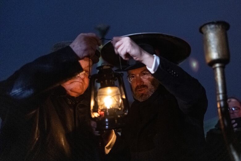 A rabbi lights a candle for a menorah in Kyiv.