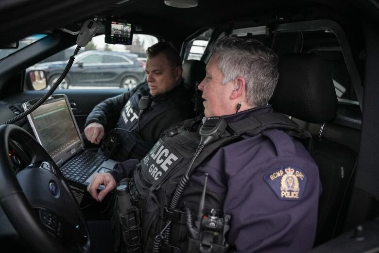 RCMP Const. Lorri Kokkola and psychiatric nurse John Obelienius listen in as a call comes through.