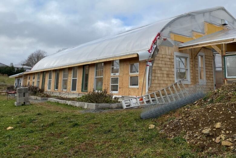 A wide view of a large greenhouse under construction.