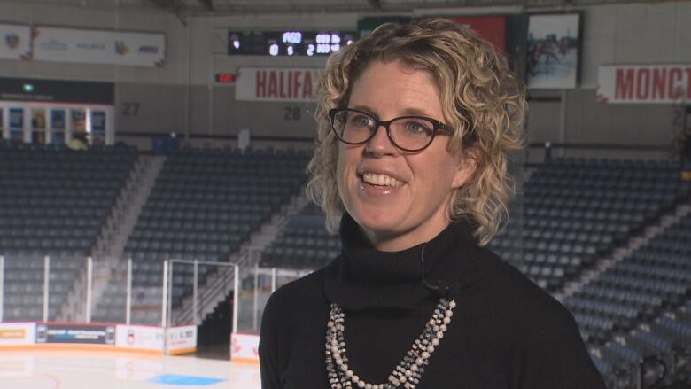 Suzanne Fougere with Scotiabank centre is shown standing inside the arena with the ice surface behind her being prepared for the World Junior event.