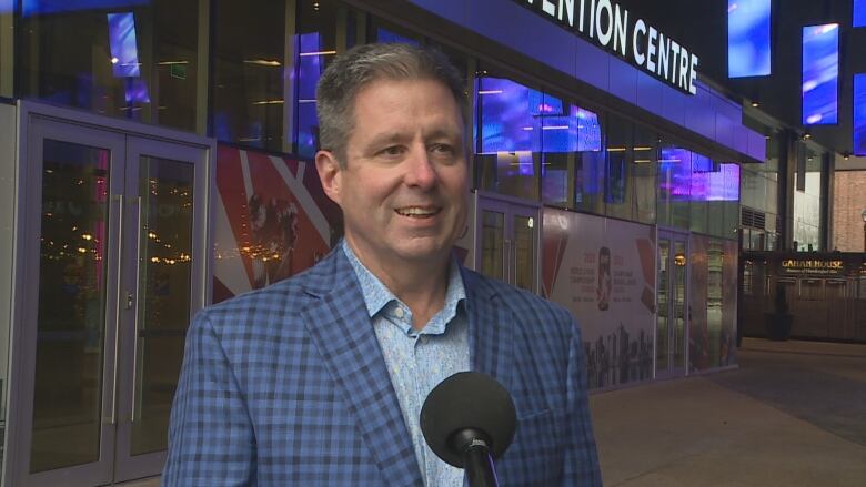 Event organizer Grant MacDonald is shown standing at Halifax's Rogers Square where big TV screens are behind him that will be showing the games.