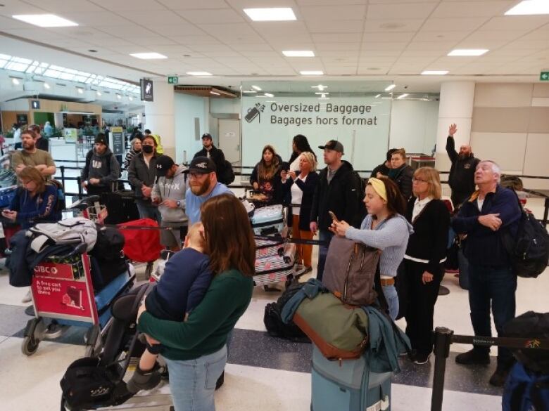 Frustrated travellers stand in Toronto's Pearson Airport.