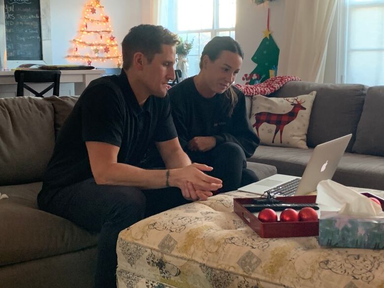 Ty and Michelle Hughes look at their lap top computer during a virtual appointment with the Princess Margaret Cancer Centre. 