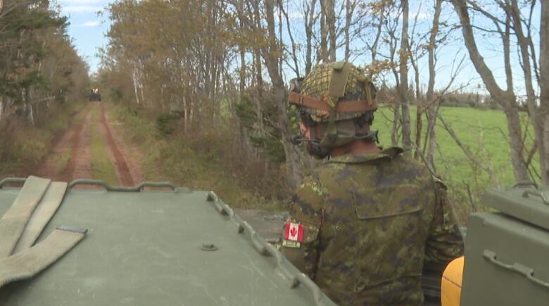 Soldier in tank on dirt road 