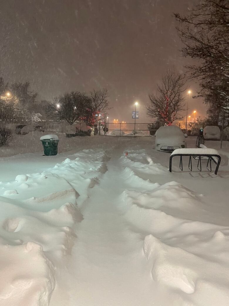 A path through the snow is pictured in the dark, early morning hours