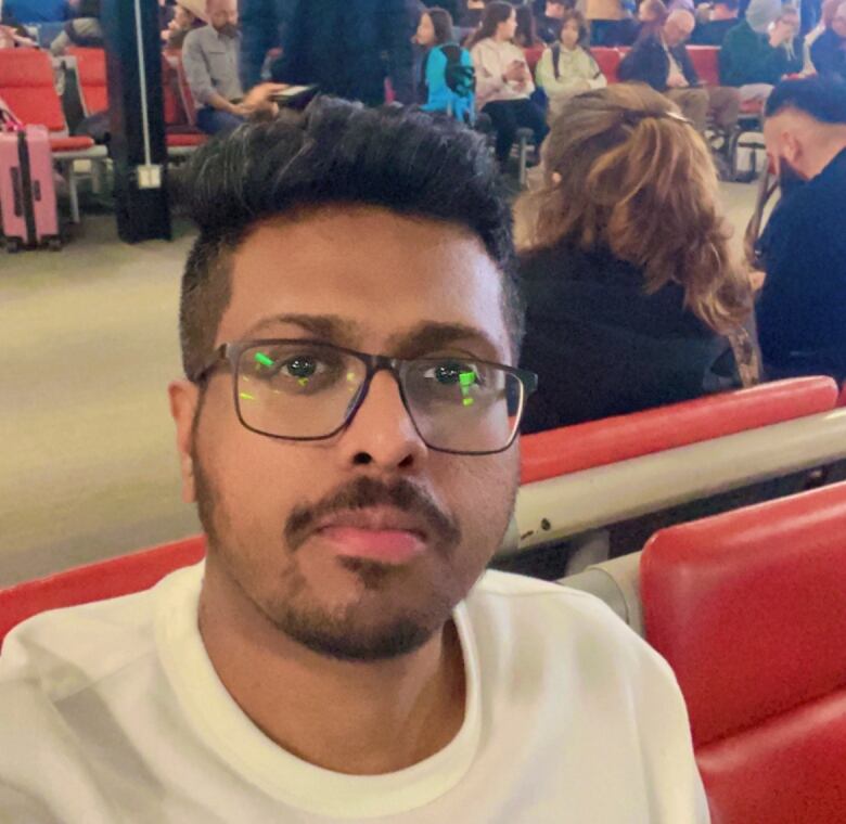 A man sits in an airport terminal.