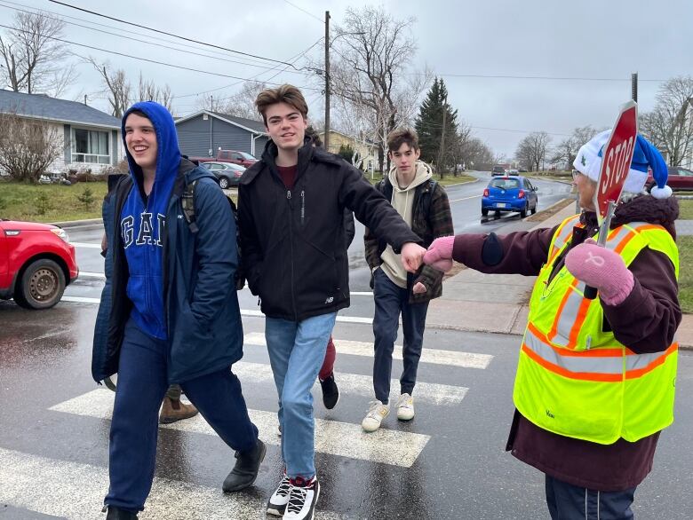 Mary Morrison, 82-year-old crossing guard, fists pumps students as they cross the street.