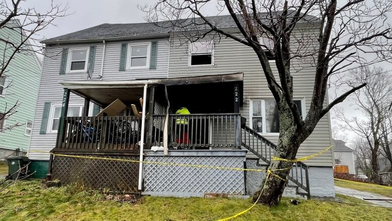 A firefighter stands at the entrance to a side-by-side duplex house that caught fire.