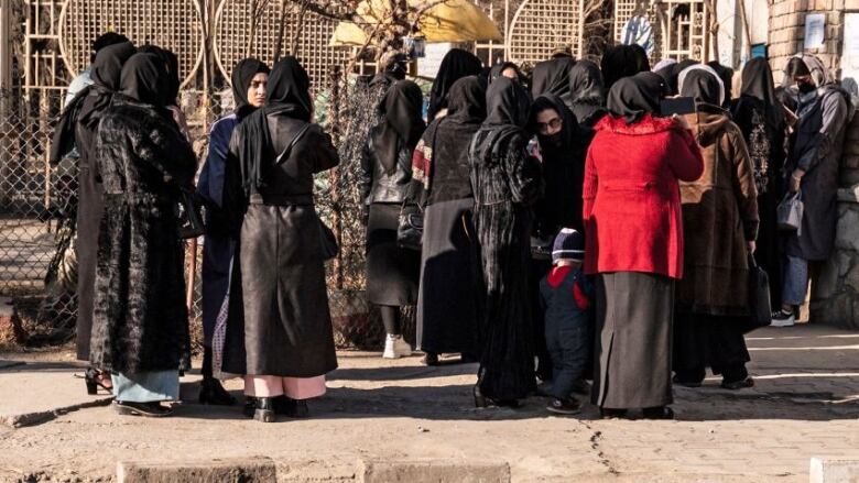 Women gather outside a university in Kabul after they were blocked from entering it.