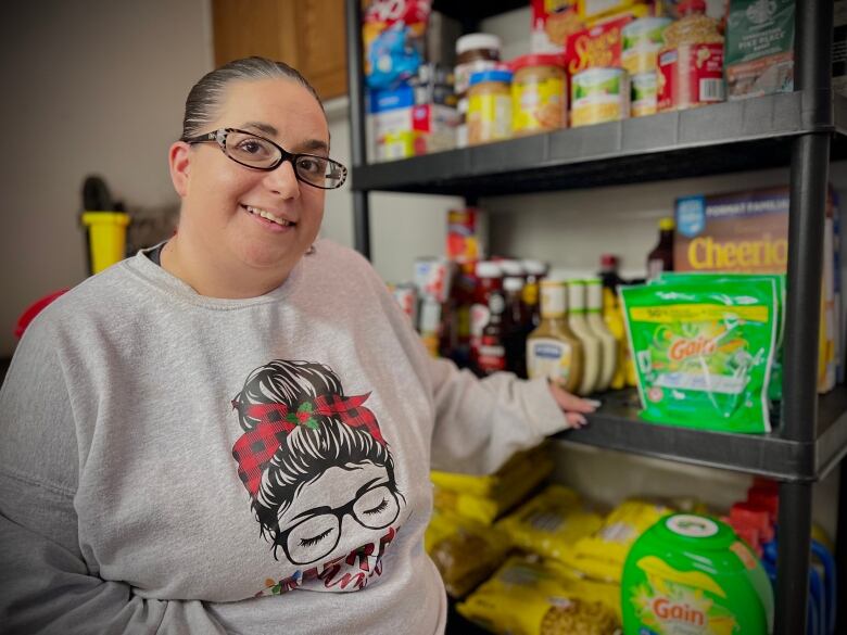 Dianne Debarros of Sarnia stands in front of her pantry full of grocery items she bought on sale.