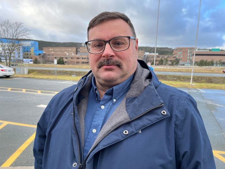 A man wearing a blue jacket stands in the CBC parking lot in St. John's.