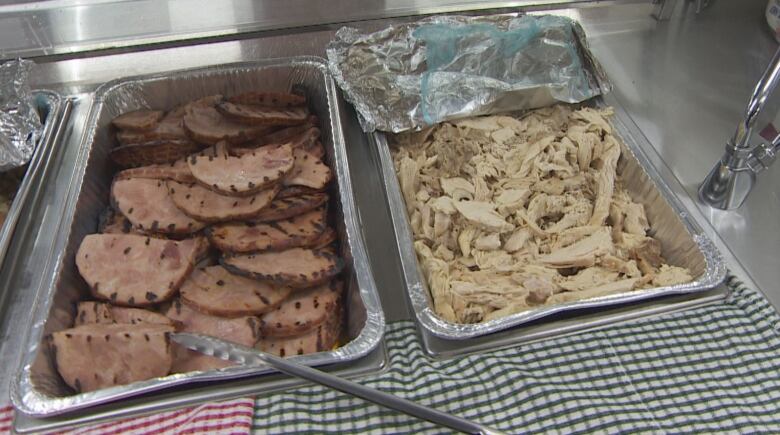 Two different meats sit in warming trays.