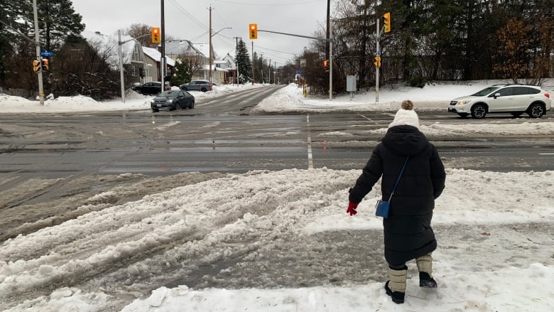 A person walks through slush at an intersection.