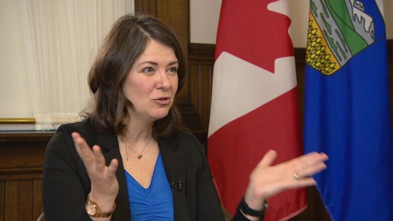 Premier Danielle Smith gestures as she speaks during an interview at the Calgary government office.