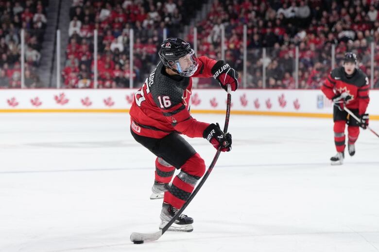 A Canadian hockey player's stick bends as he winds up a wrist shot.