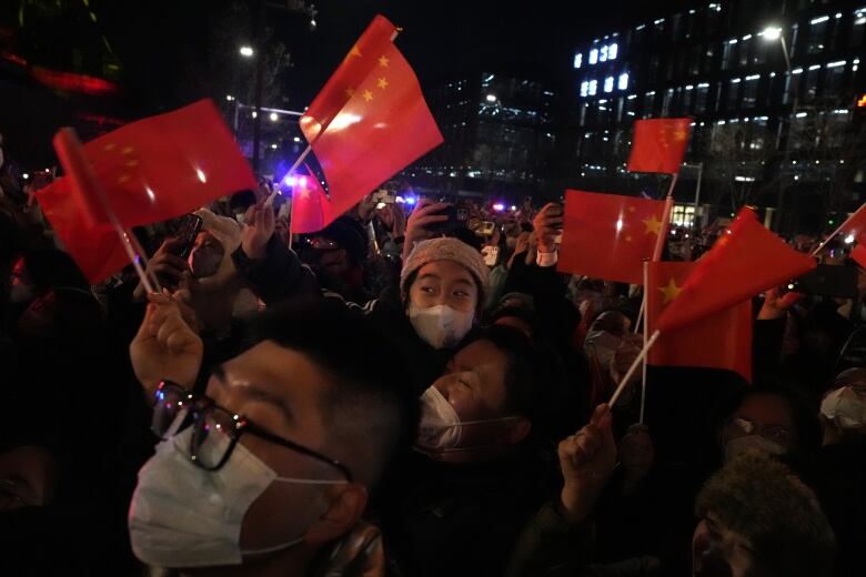 A group of people waving red flags gather in Shougang Park in Beijing to celebrate the new year.