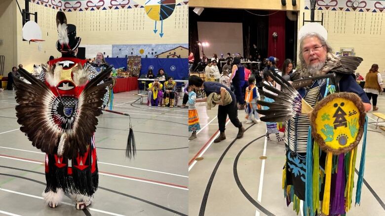 Powwow dancers stand in a gym wearing feathers and colourful clothing.