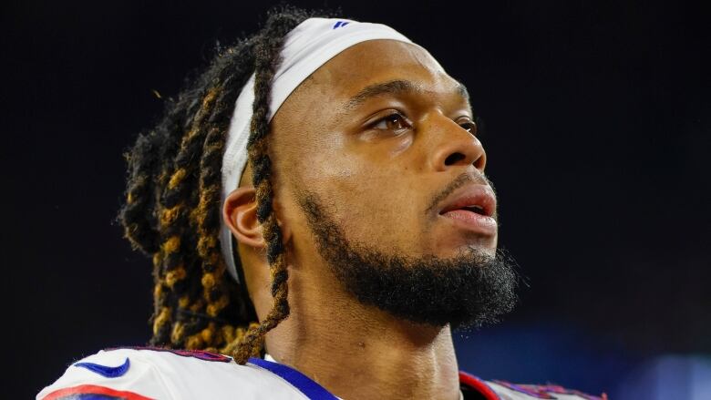 A man in football gear looks off camera.