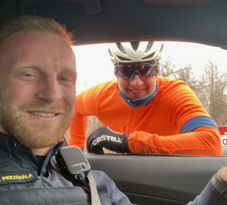 An OPP officer and a man in bicycle gear pose for a selfie. 