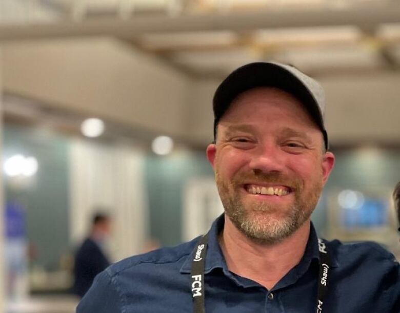 A man in a cap smiles for the camera.