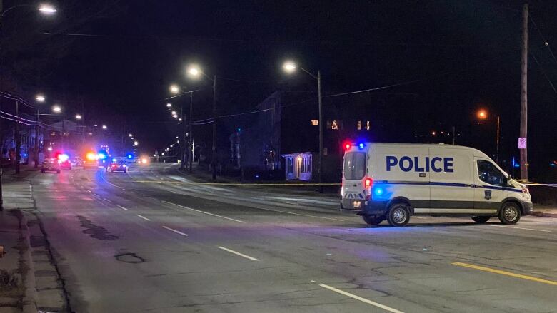 Multiple police vehicles blocking a street at night.