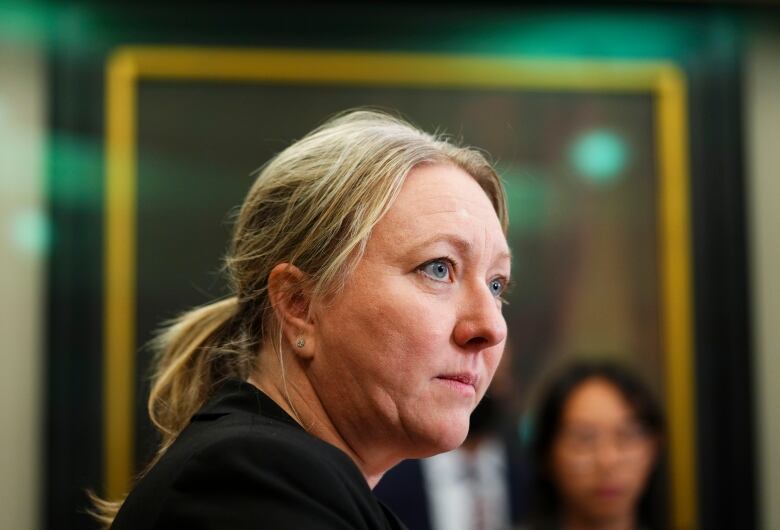 A politician listens during an announcement.