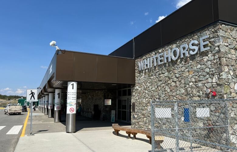 A view of the front of a building and sidewalk in front. The building has 'Whitehorse' in big letters on the front.