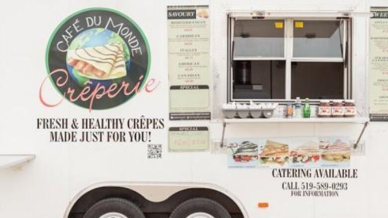 A white food truck with the logo 