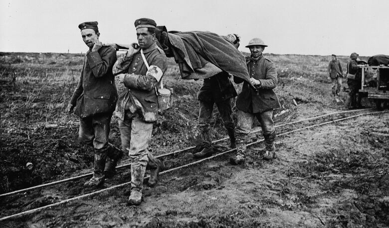 Several men use a stretcher to carry a wounded soldier at Vimy Ridge, France, in April 1917.