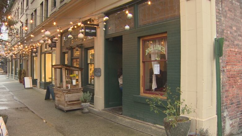 An exterior shot of the restaurant on a street decorated for Christmas.