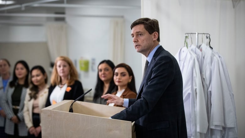 B.C. Premier David Eby stands at a podium during a news conference.