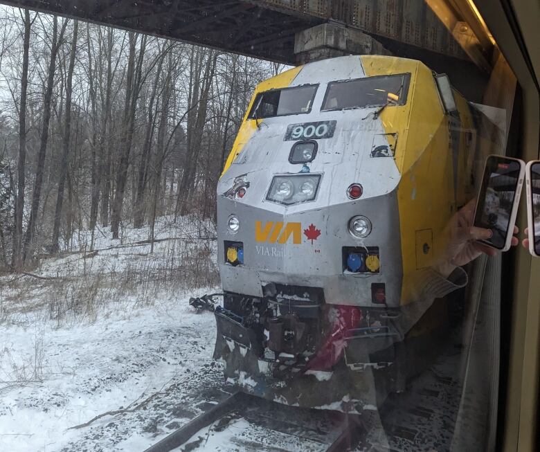 A Via Rail train is seen from the carriage of another train.