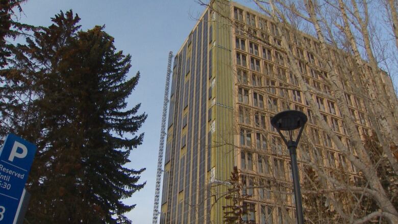 A large building at the University of Calgary, with unfinished solar panels being installed on the south facade.