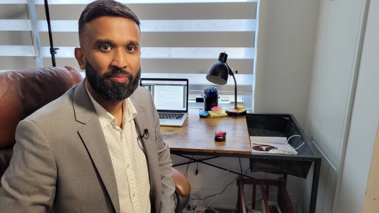 A man sitting in a chair inside his office.