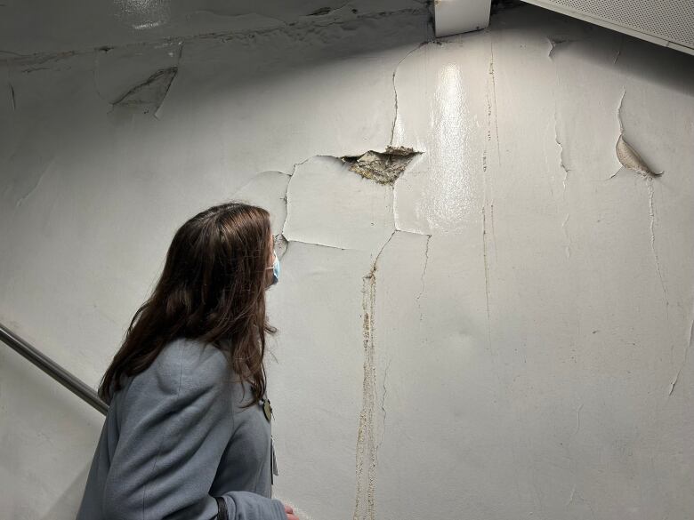 Coun. Marty Carr examines a wall at Parliament Station that has evidence of water infiltration and cracking. 