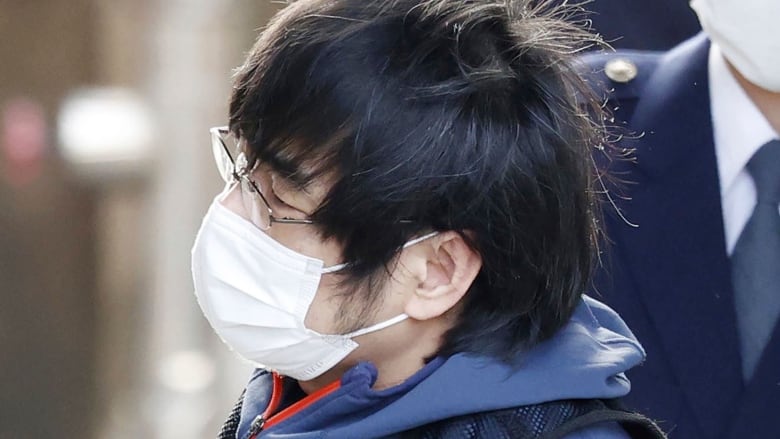 A closeup of a man in glasses wearing a COVID mask.