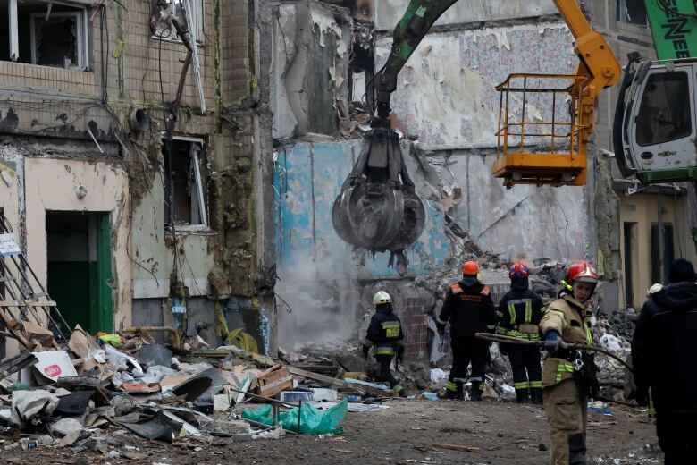 Debris, a heavily damaged building and a crane are shown.