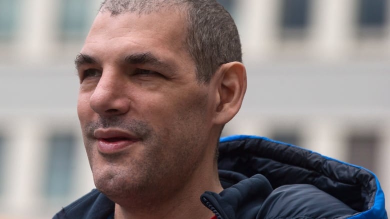 Closeup photo of former Vancouver Canucks' enforcer Gino Odjick smiling.