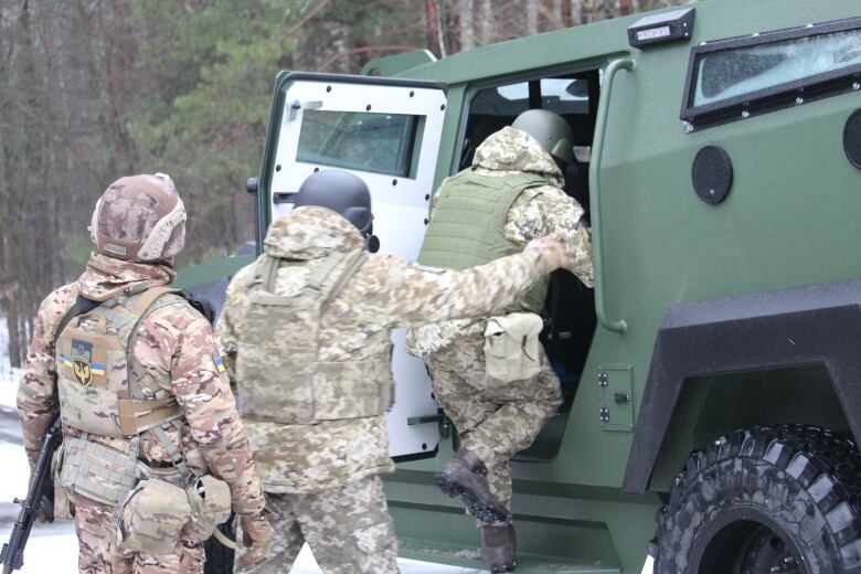 Ukrainian troops pile into a Senator APC near the border with Belarus.