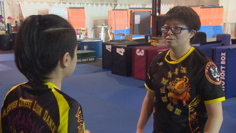 Eugenia Chau, head of the Vancouver Lion Dance association, is talking to one of her young students at the lion dance rehearsal space. 