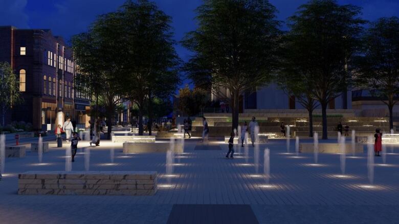 A night time shot of lights and a water fountain with trees in the background. 