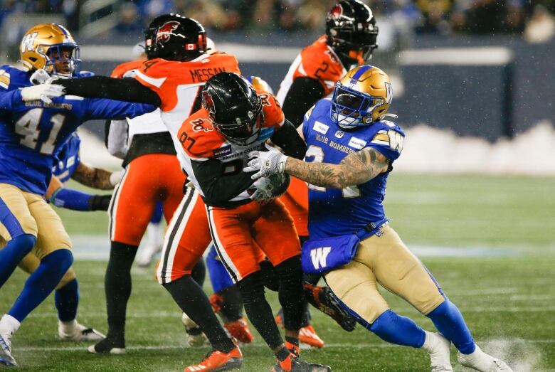 Winnipeg Blue Bombers' Mike Miller (24) tackles BC Lions' Terry Williams (87) during the second half of CFL western final action in Winnipeg, Sunday, Nov. 13, 2022. 