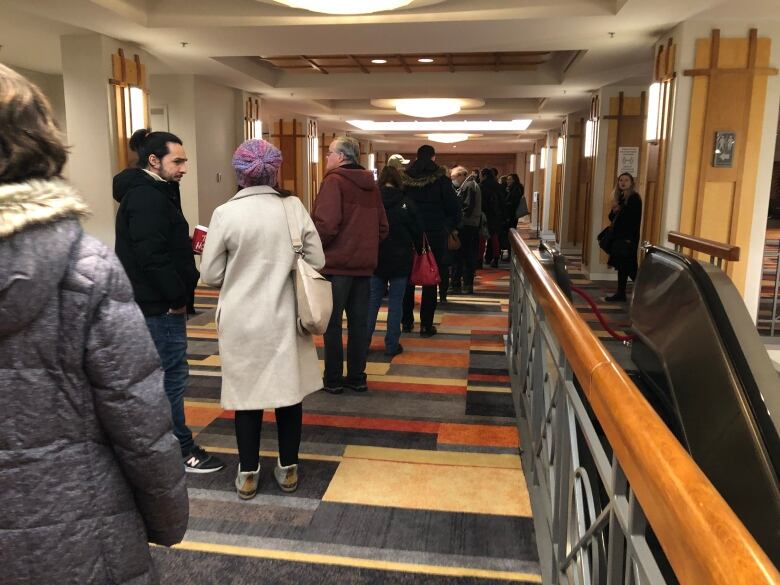 People lining up to enter a hotel ballroom.