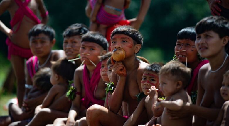 A group of children is sitting on the ground.