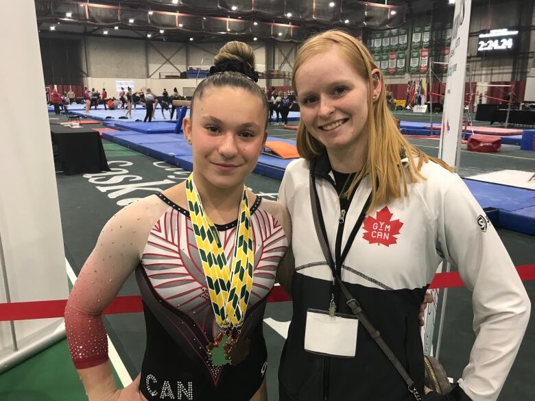 Two gymnasts stand next to each other