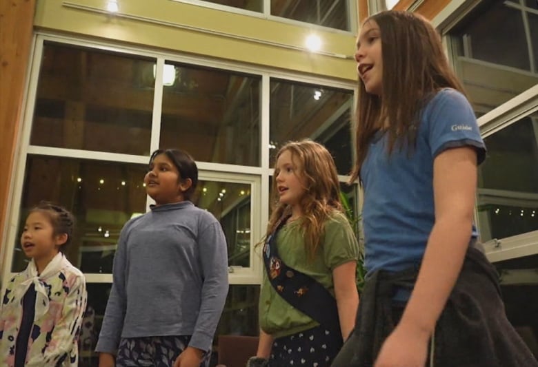 A group of Girl Guides stands in a circle.