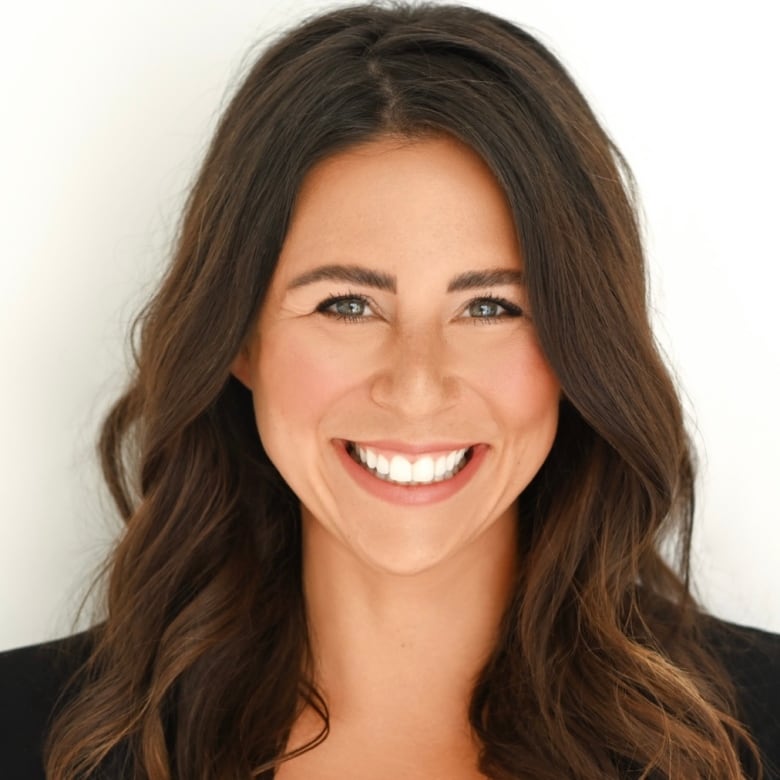 A headshot of a smiling woman with brown hair.