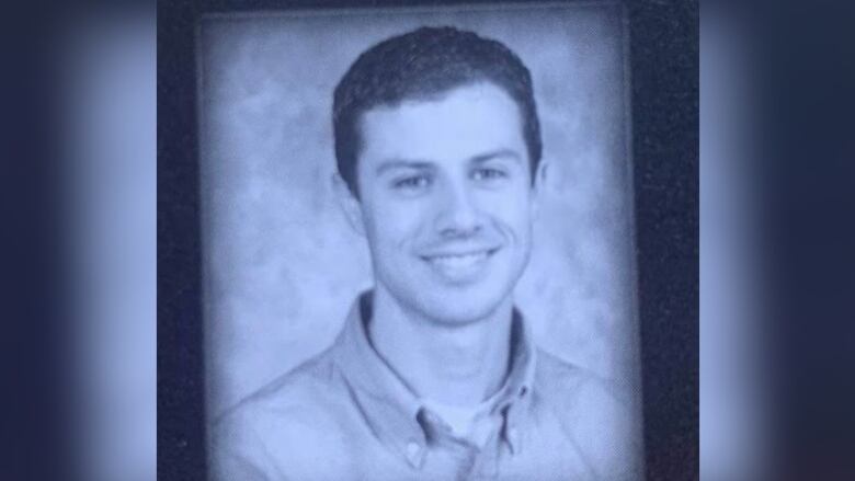 Black and white yearbook photo shows a smiling young teacher in a button-up shirt.