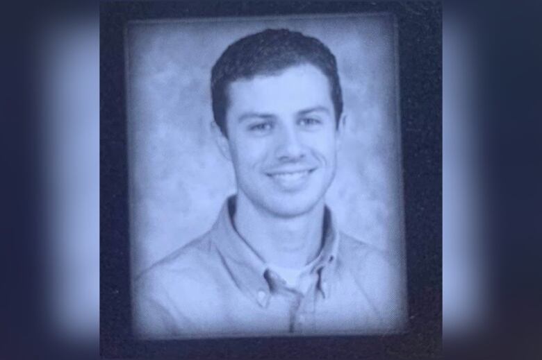 Black and white yearbook photo shows a smiling young teacher in a button-up shirt.